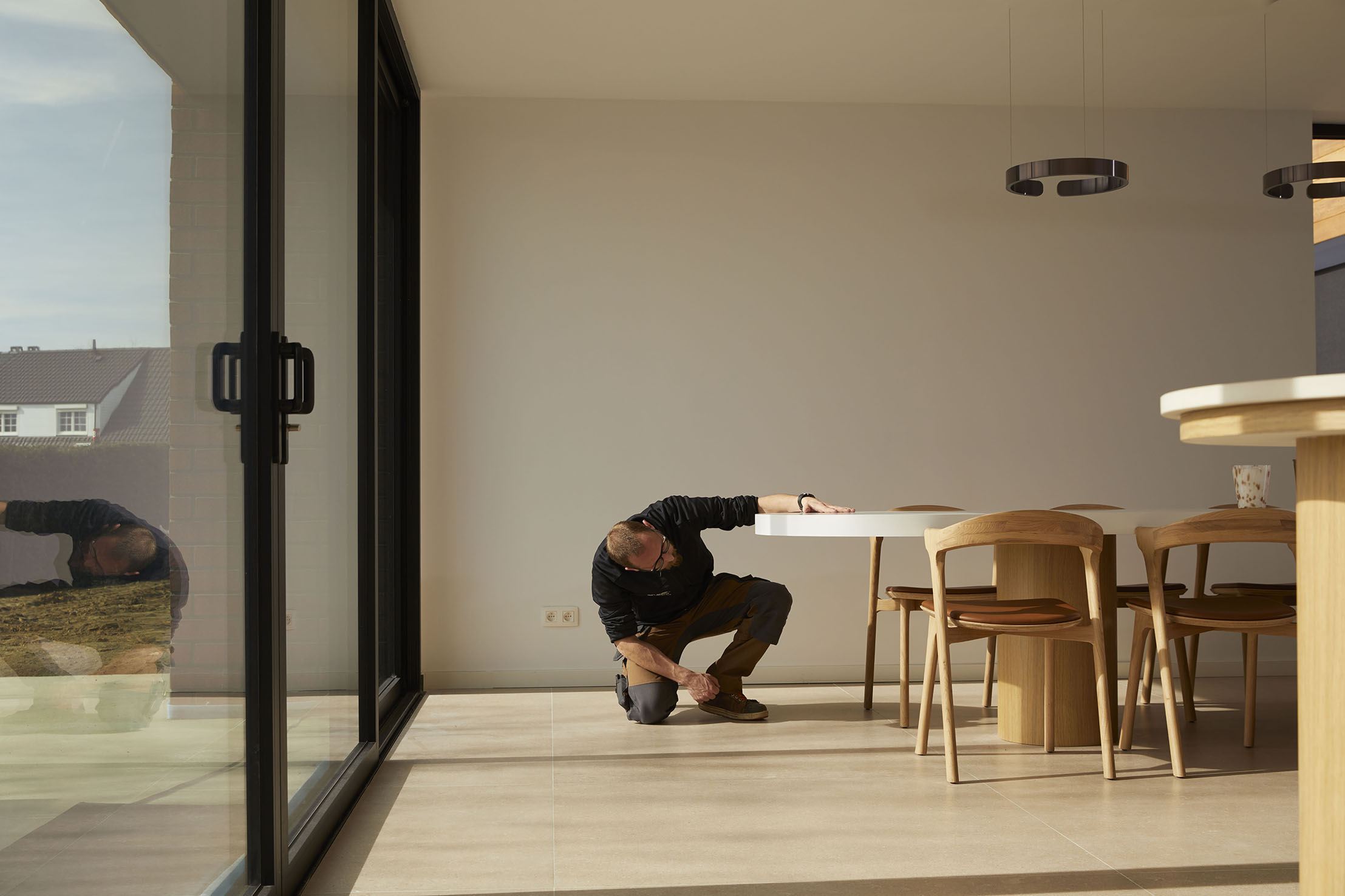 Technicien Bo Buro contrôlant la finition d’une table ronde sur mesure en chêne, aménagement Kerr France